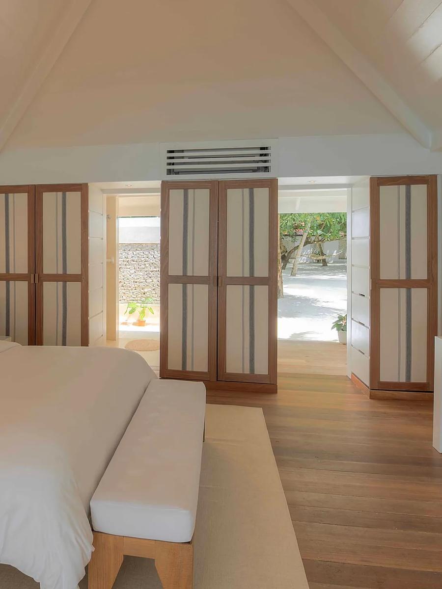 Bedroom interior of a Beach Front Villa at Diamonds Athuruga, opening onto its private veranda