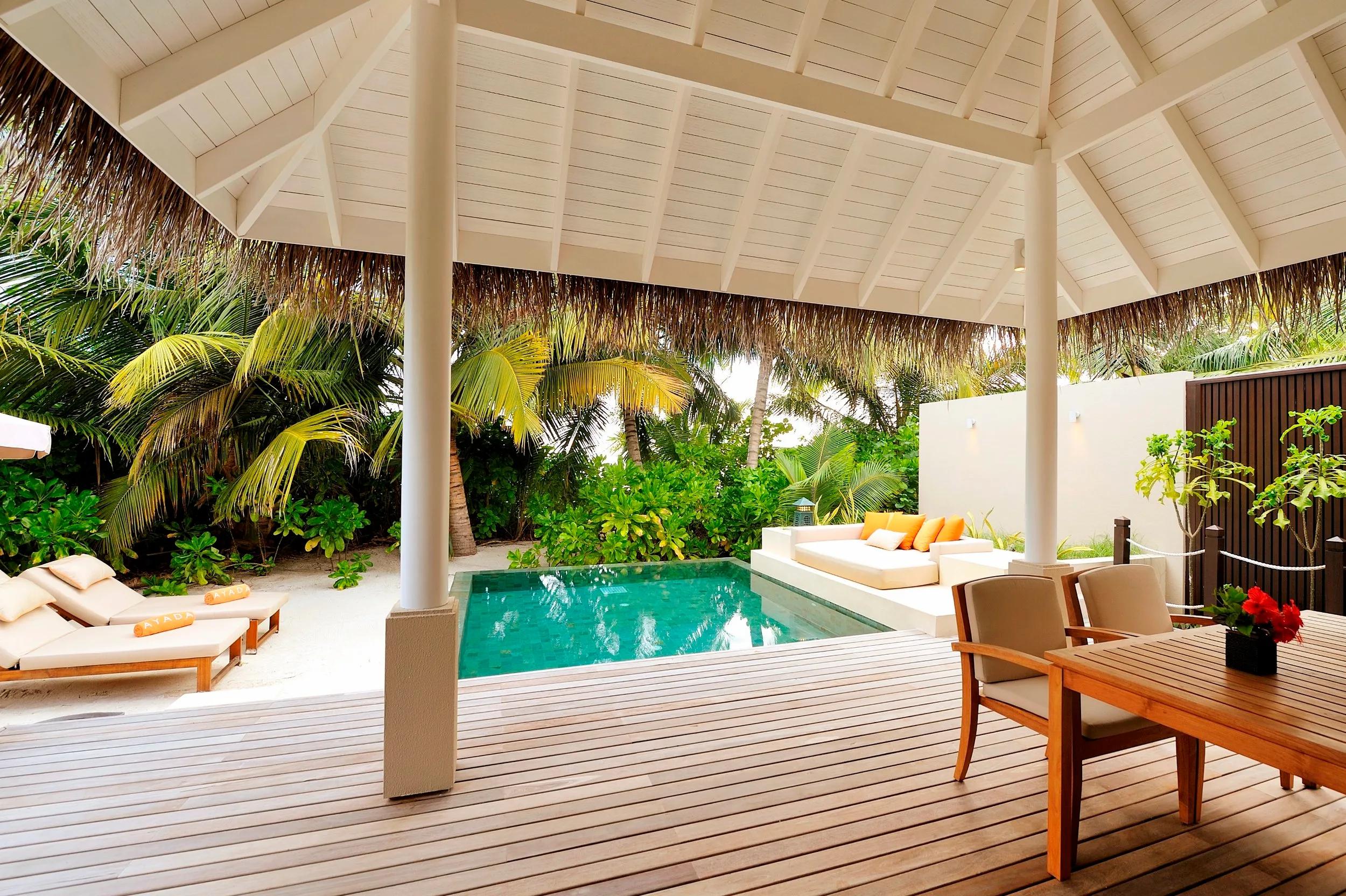 A Sunset Beach Suite's covered dining pavilion and plunge pool, framed by palms