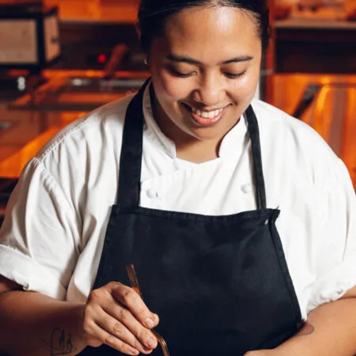 A guest seated at a chef's table watching a tasting menu being prepared