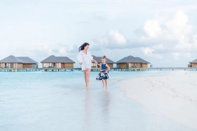 A family playing together in the shallow, sheltered lagoon of a Maldives resort