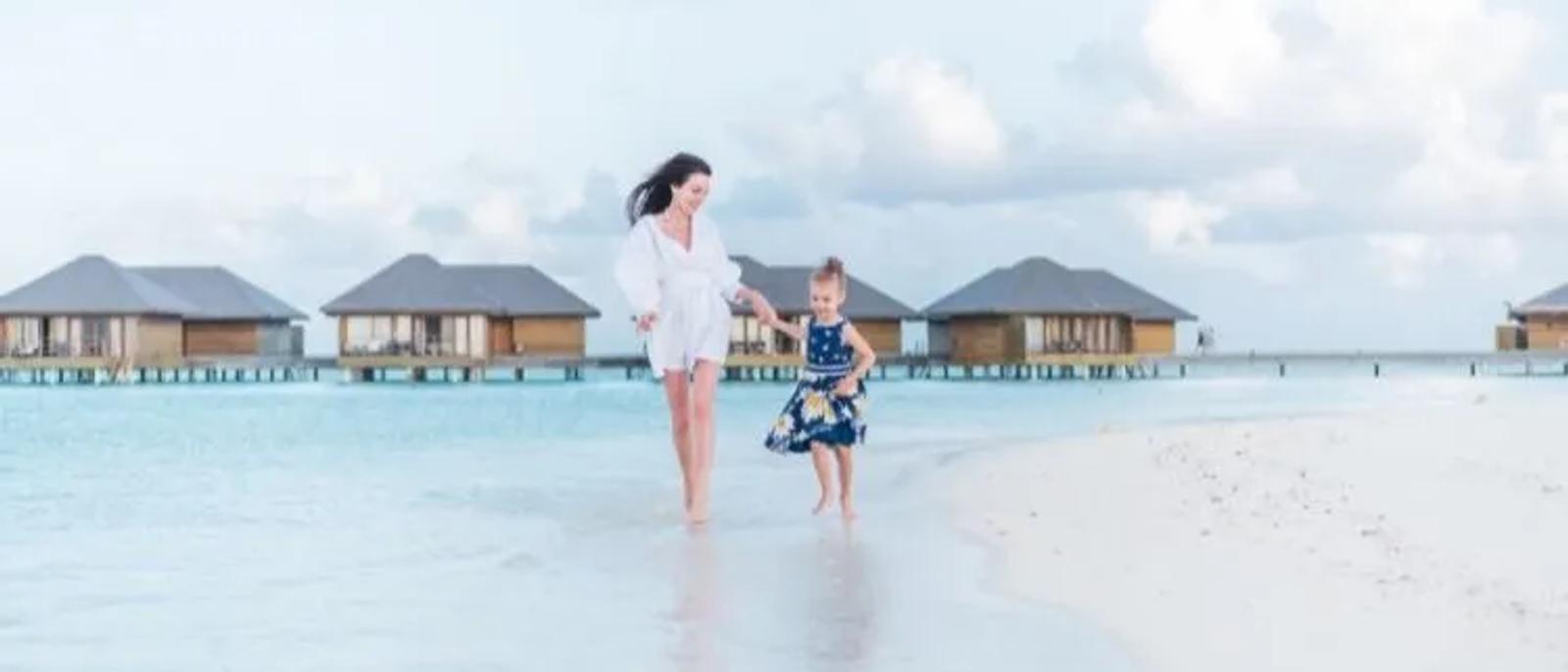 Family enjoying a luxury Maldives resort beach and lagoon