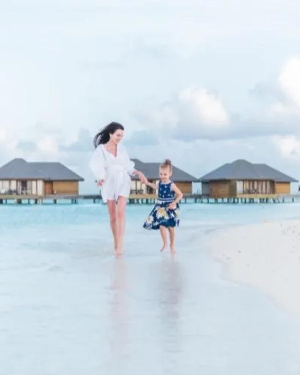 A family playing together in the shallow, sheltered lagoon of a Maldives resort