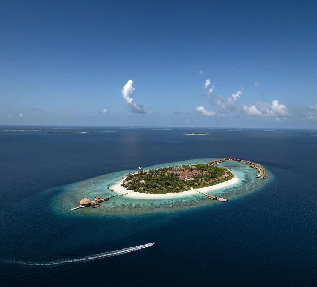 Overhead drone view of Bodufushi Island's overwater villas fanning out into the Raa Atoll lagoon