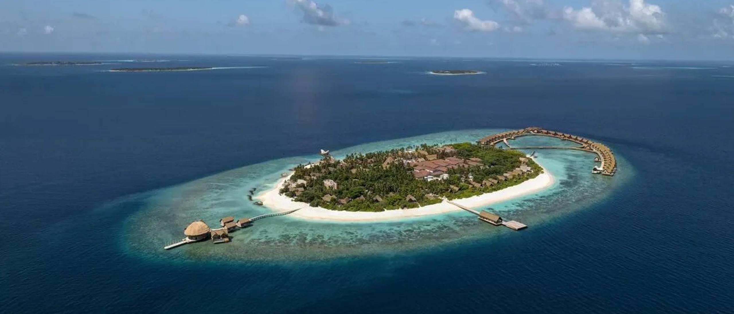 Overhead drone view of Bodufushi Island's overwater villas fanning out into the Raa Atoll lagoon