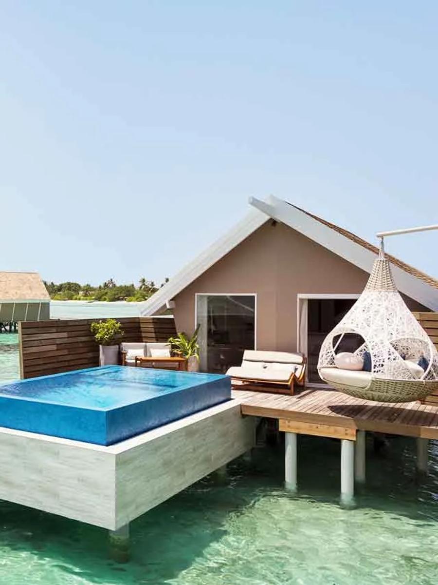 An Overwater Infinity Pool Villa's private pool extending toward the lagoon, with a hanging day bed on the deck