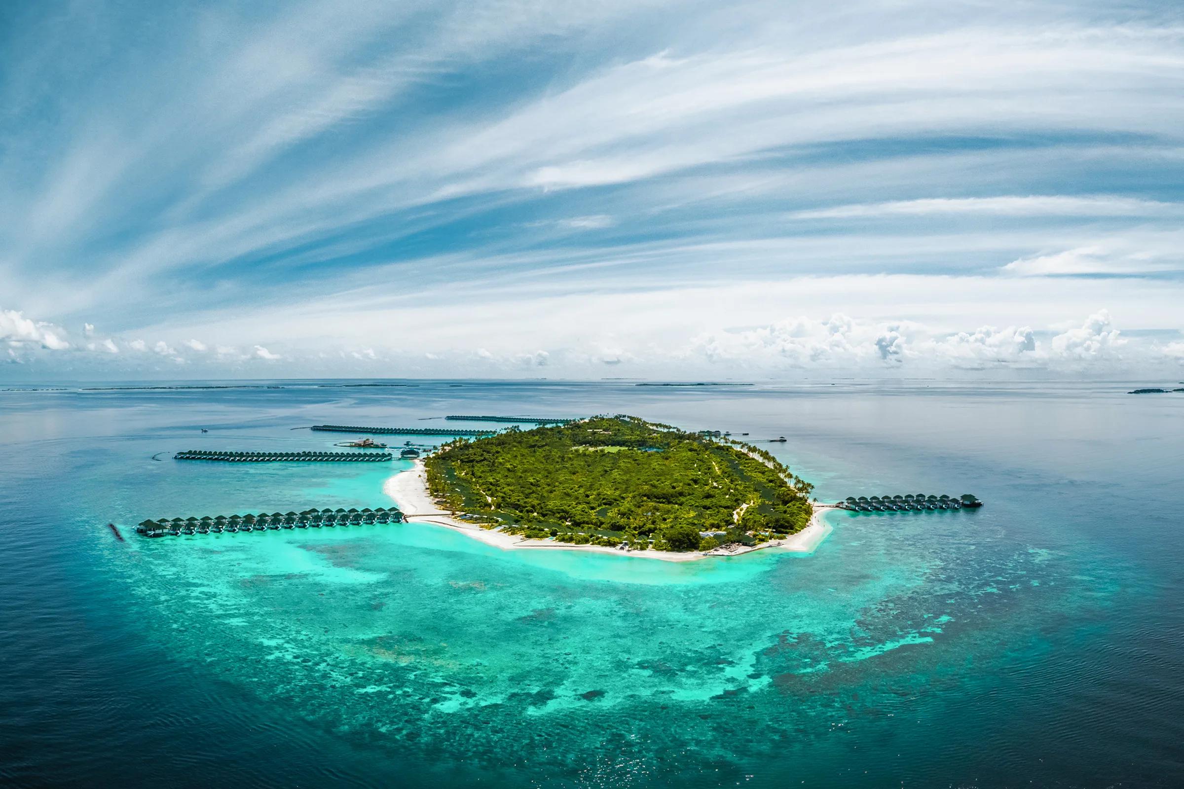 Siyam World's island from the air, ringed by reef in Noonu Atoll