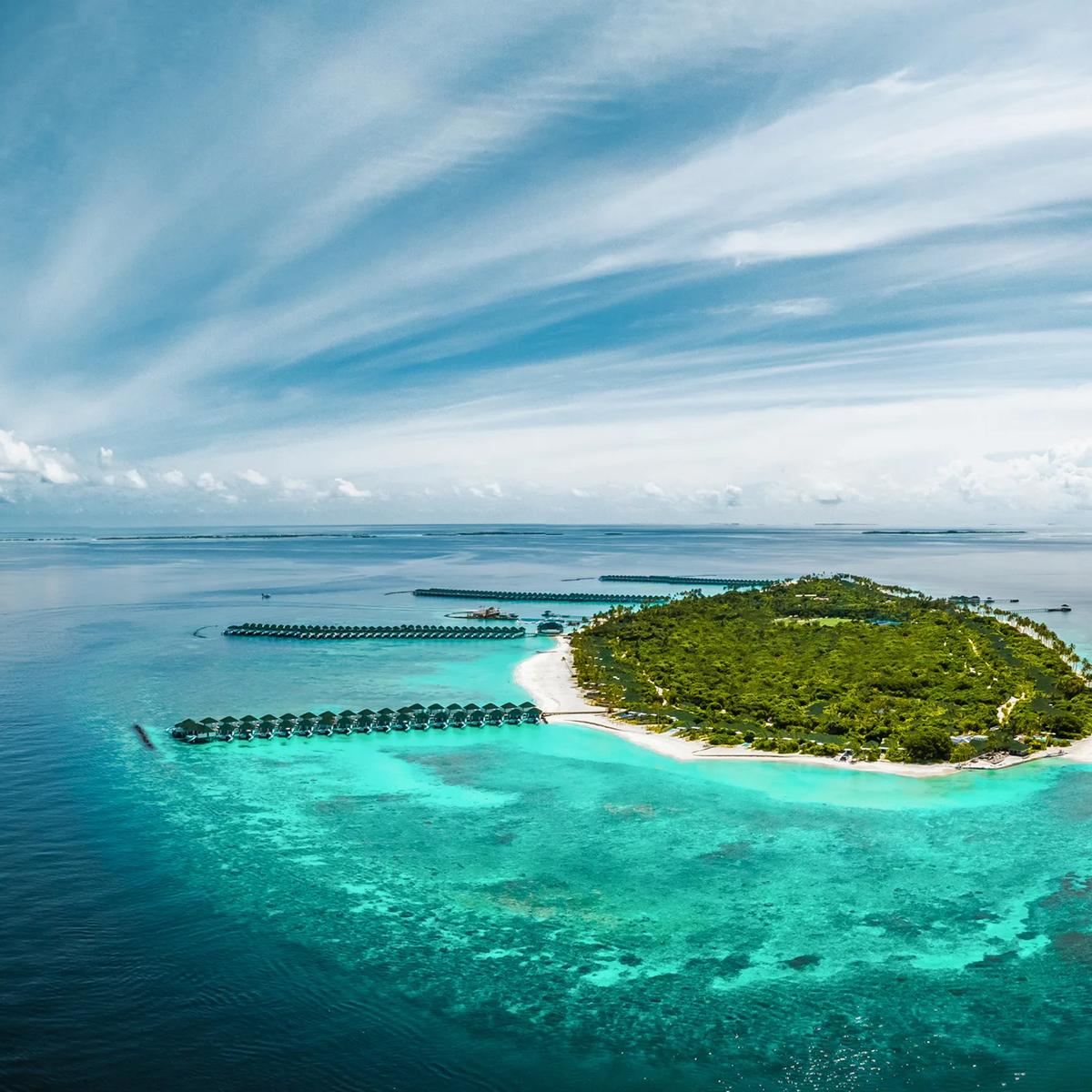 Siyam World's island from the air, ringed by reef in Noonu Atoll