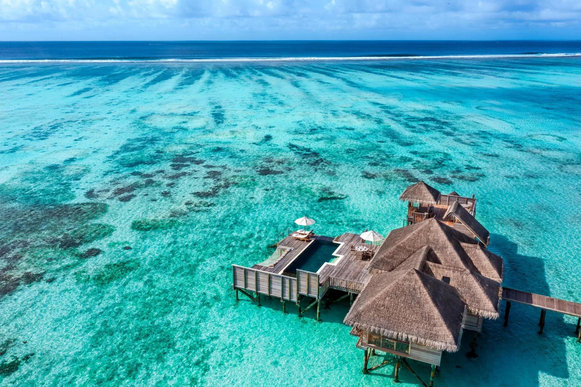 Aerial view of a Residence with Pool at Gili Lankanfushi, showing its infinity pool over the lagoon