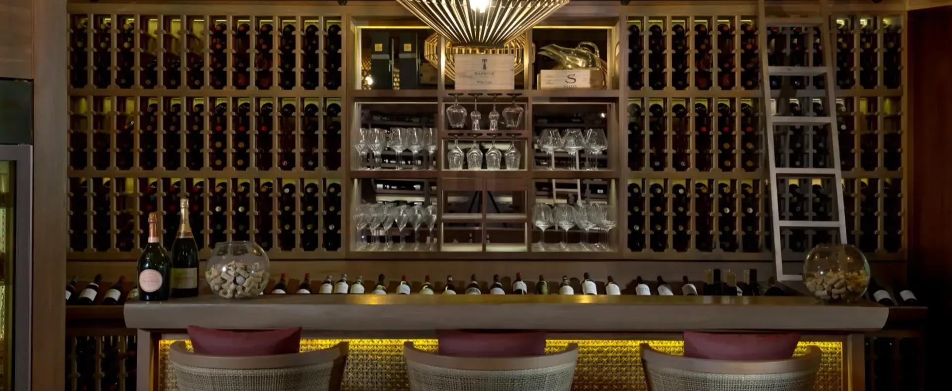 Wine racks and glassware inside the Vakkaru Reserve cellar, lit by a starburst pendant light