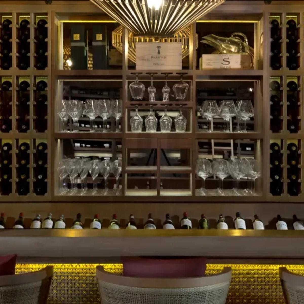 Interior of the Vakkaru Reserve wine cellar, floor-to-ceiling wine racks and glassware displayed behind a tasting bar