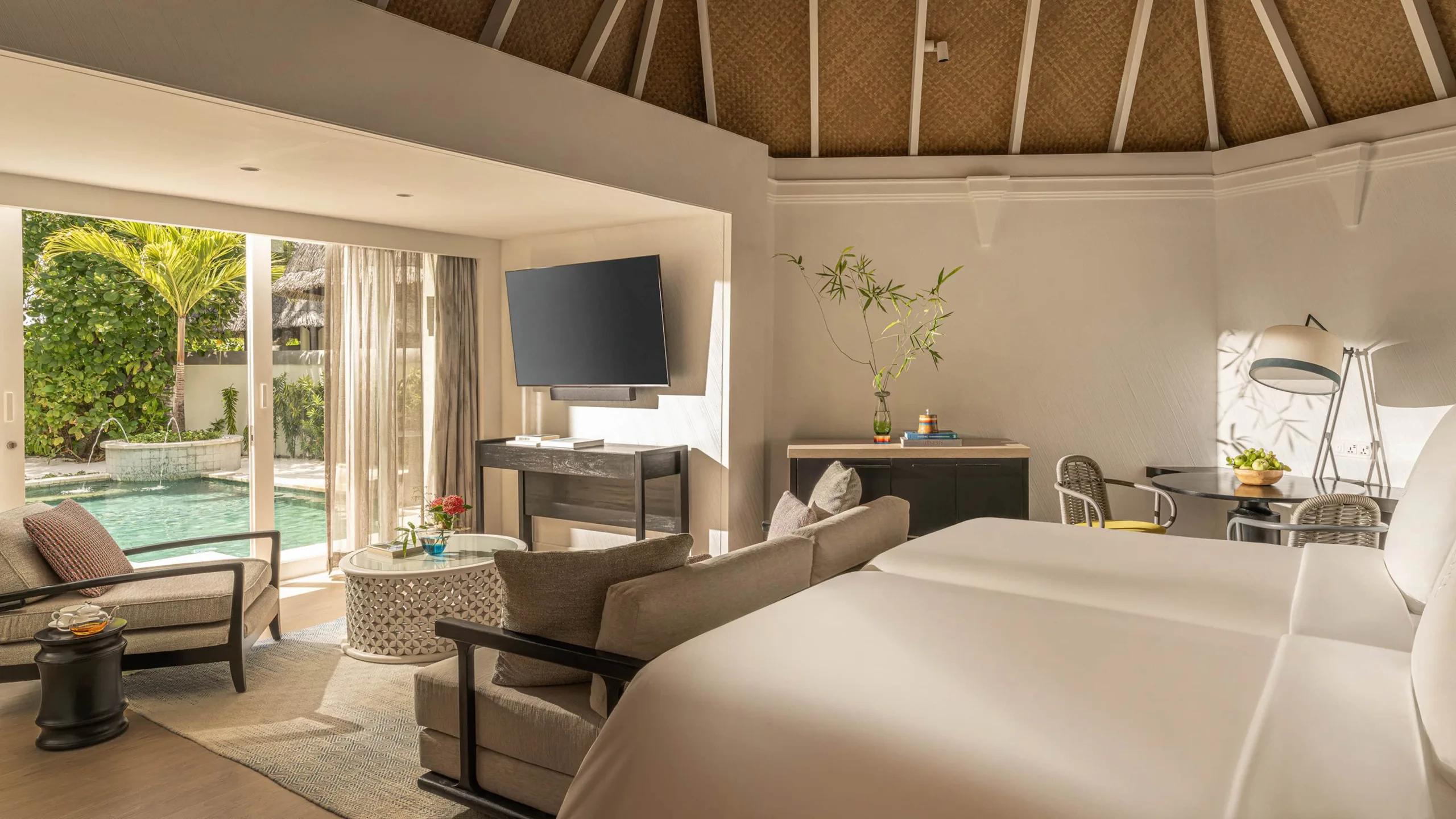 A Deluxe Beach Pavilion bedroom opening onto its private pool and garden