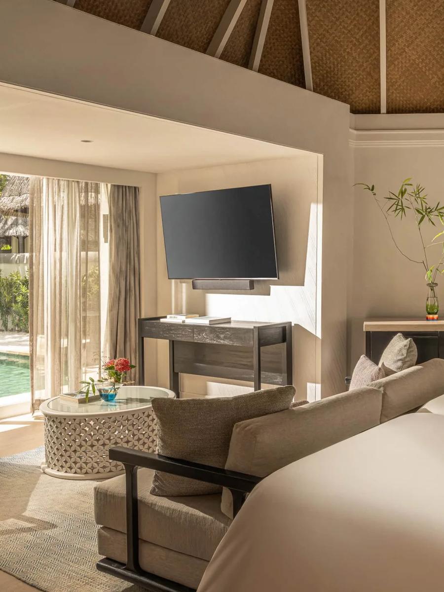 A Deluxe Beach Pavilion bedroom opening onto its private pool and garden