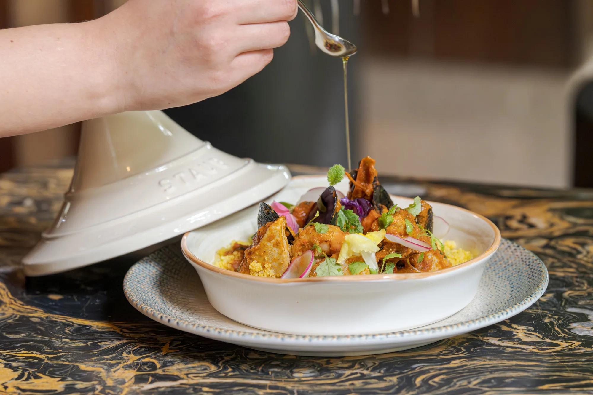 A mussel and tomato tagine finished tableside with an oil drizzle at TUH'U, JOALI's Levant restaurant