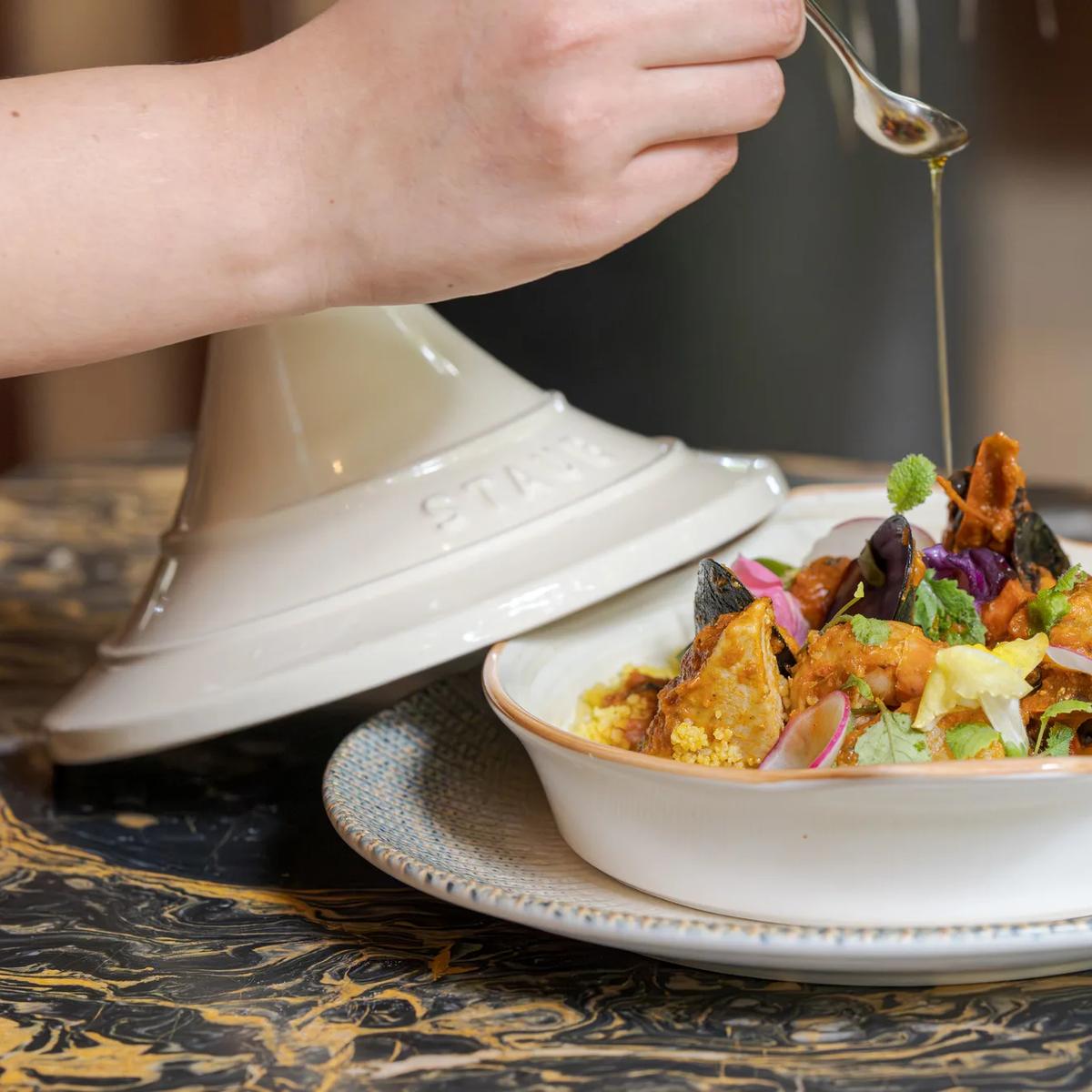 A mussel and tomato tagine finished tableside with an oil drizzle at TUH'U, JOALI's Levant restaurant