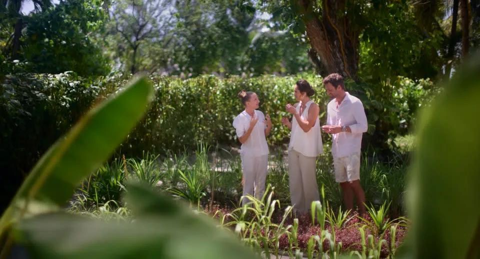 Three guests taking part in a Spice Spoons cooking class in a garden setting
