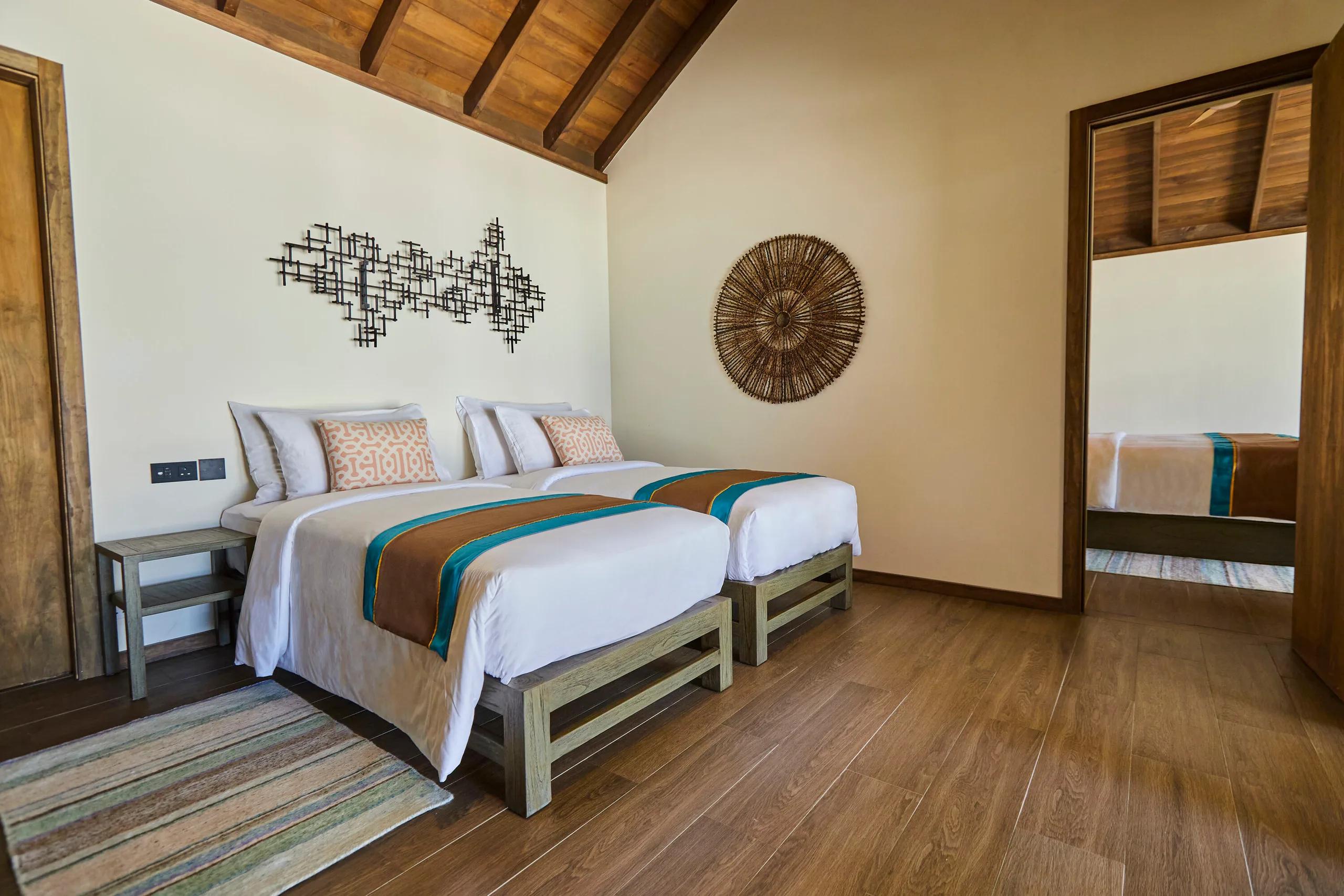 A twin-bed bedroom inside a Three Bedroom Villa at Jawakara, connecting through to a second bedroom beyond