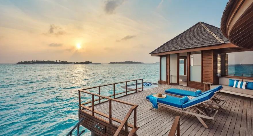 The private deck of a Sunrise Over Water Suite, with loungers set above the lagoon