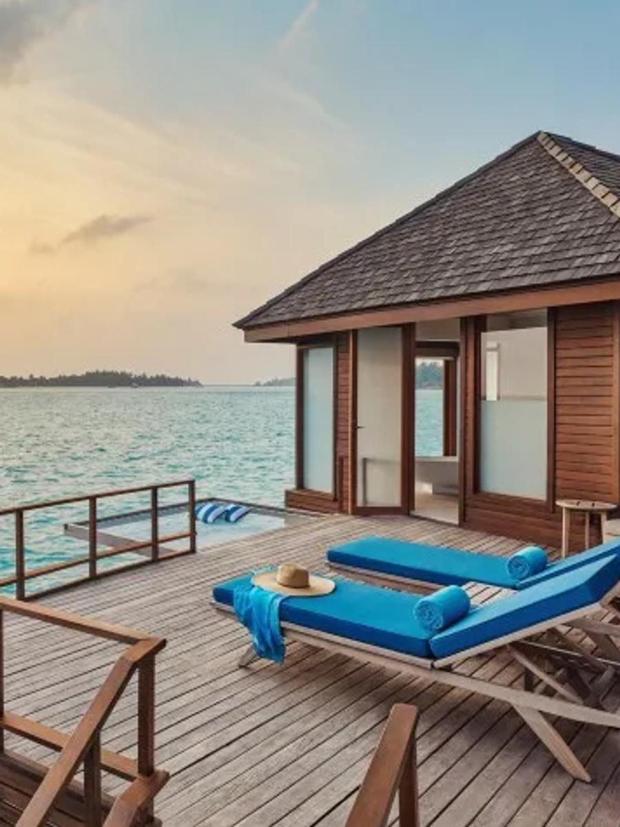 The private deck of a Sunrise Over Water Suite, with loungers set above the lagoon