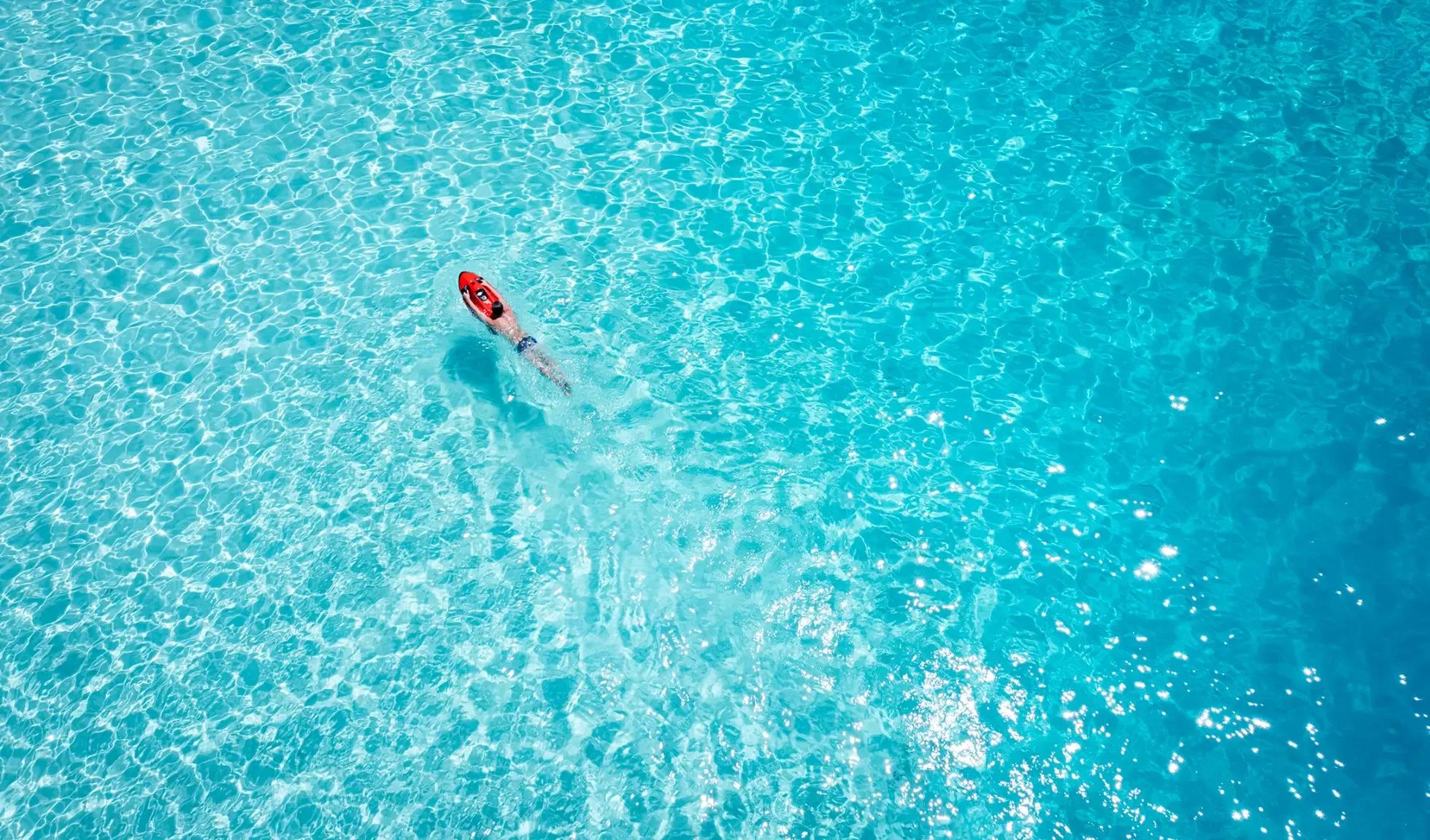 Aerial view of Niva Kurumba Maldives and its surrounding lagoon, the reef edge visible just off the beach
