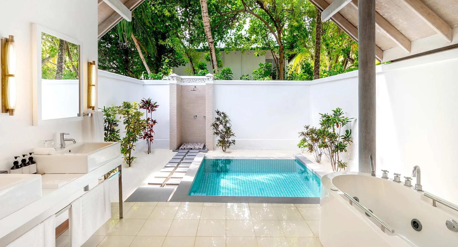 The outdoor bathroom and private pool of a Beach Villa with Private Pool, set among garden planting