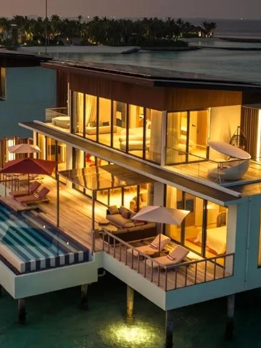 A two-storey overwater villa at SO/ Maldives at twilight, its rooftop deck and freestanding tub visible above a private pool — matching the Two-Bedroom Ocean Water Pool Atelier's two-level design