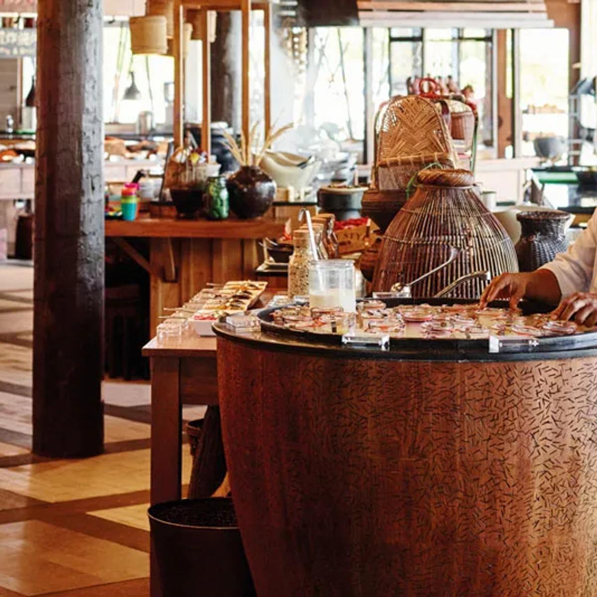 Chefs preparing food at the live cooking stations inside East Market, LUX* South Ari Atoll's South Asian breakfast-and-dinner restaurant