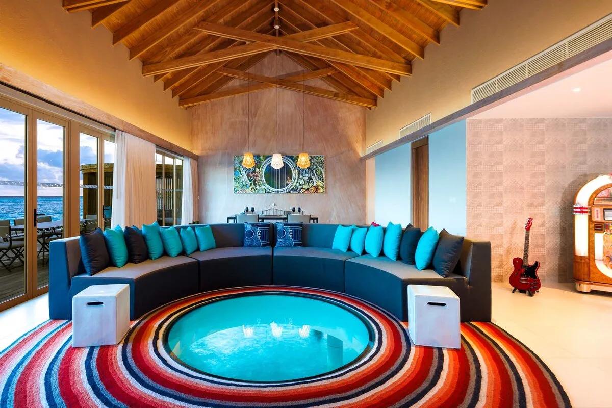Inside the Rock Star Villa's living room, its sunken glass-floored plunge feature and jukebox visible