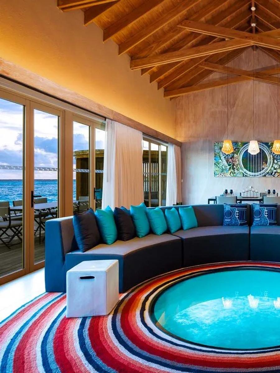 Inside the Rock Star Villa's living room, its sunken glass-floored plunge feature and jukebox visible