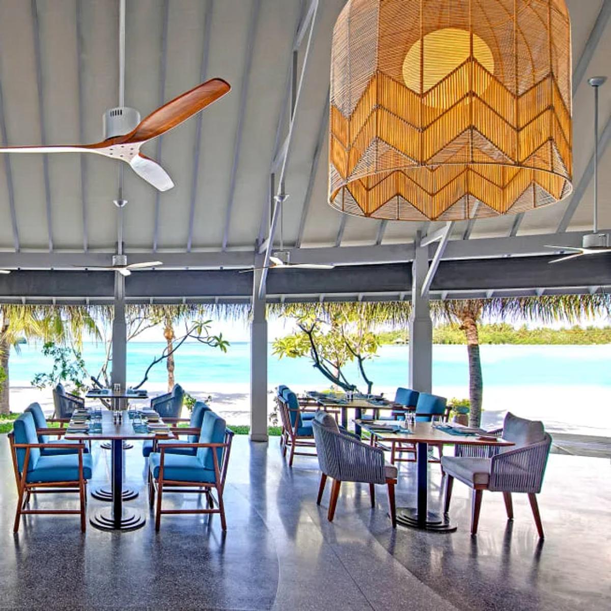 Fushi Café's open-air dining room with rattan lampshades and beach views