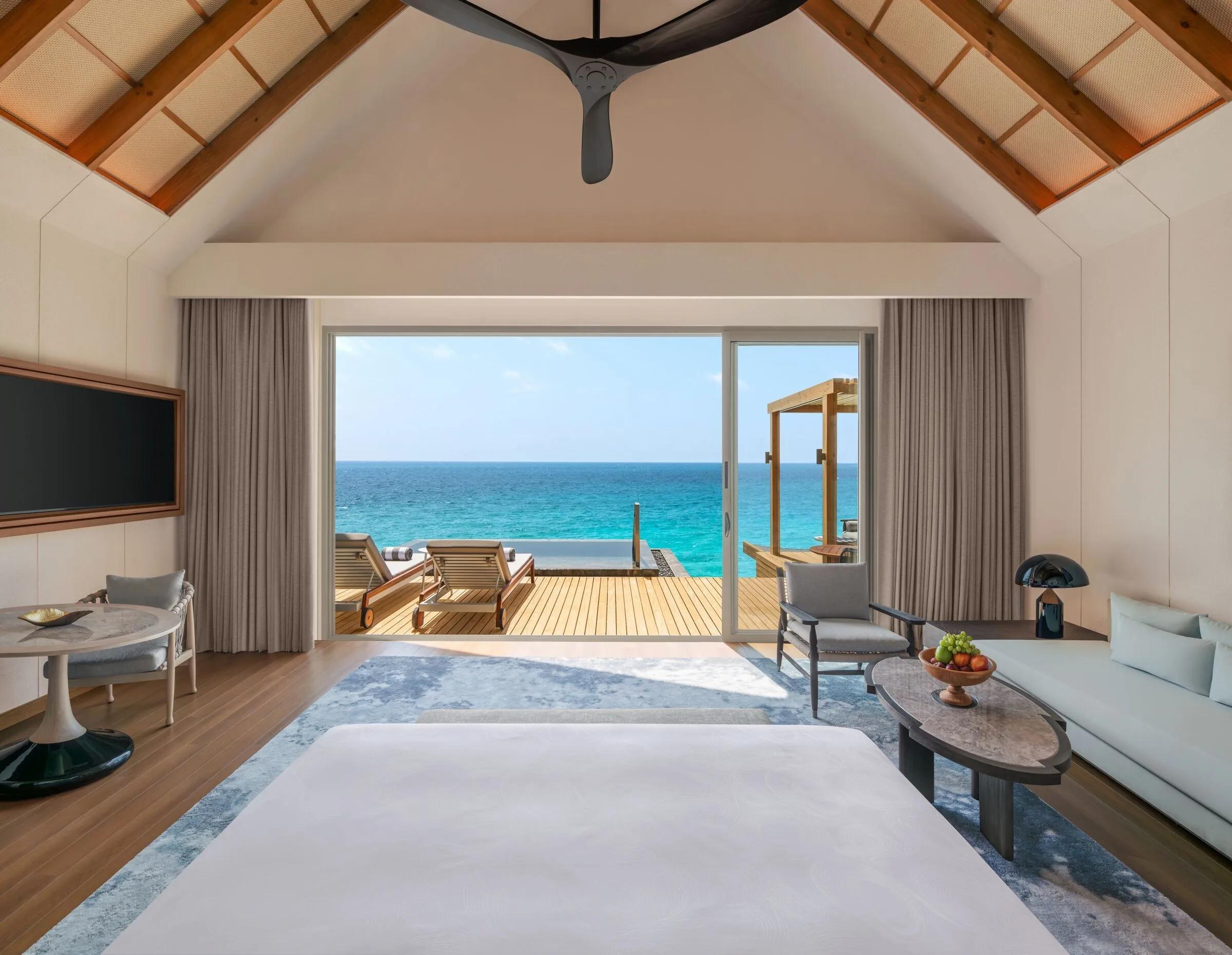 The living area of a 1 Bedroom Overwater Pool Villa, opening onto its deck over the lagoon