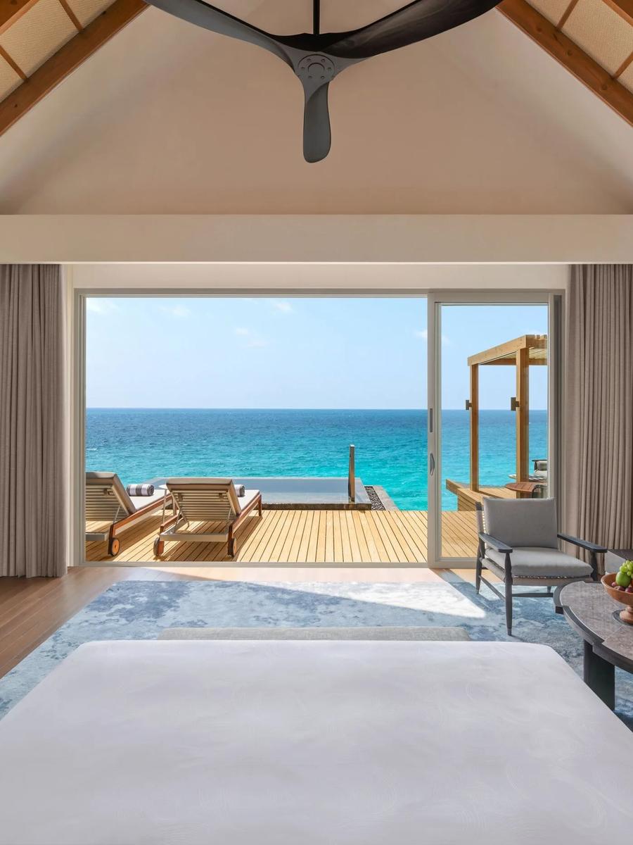 The living area of a 1 Bedroom Overwater Pool Villa, opening onto its deck over the lagoon