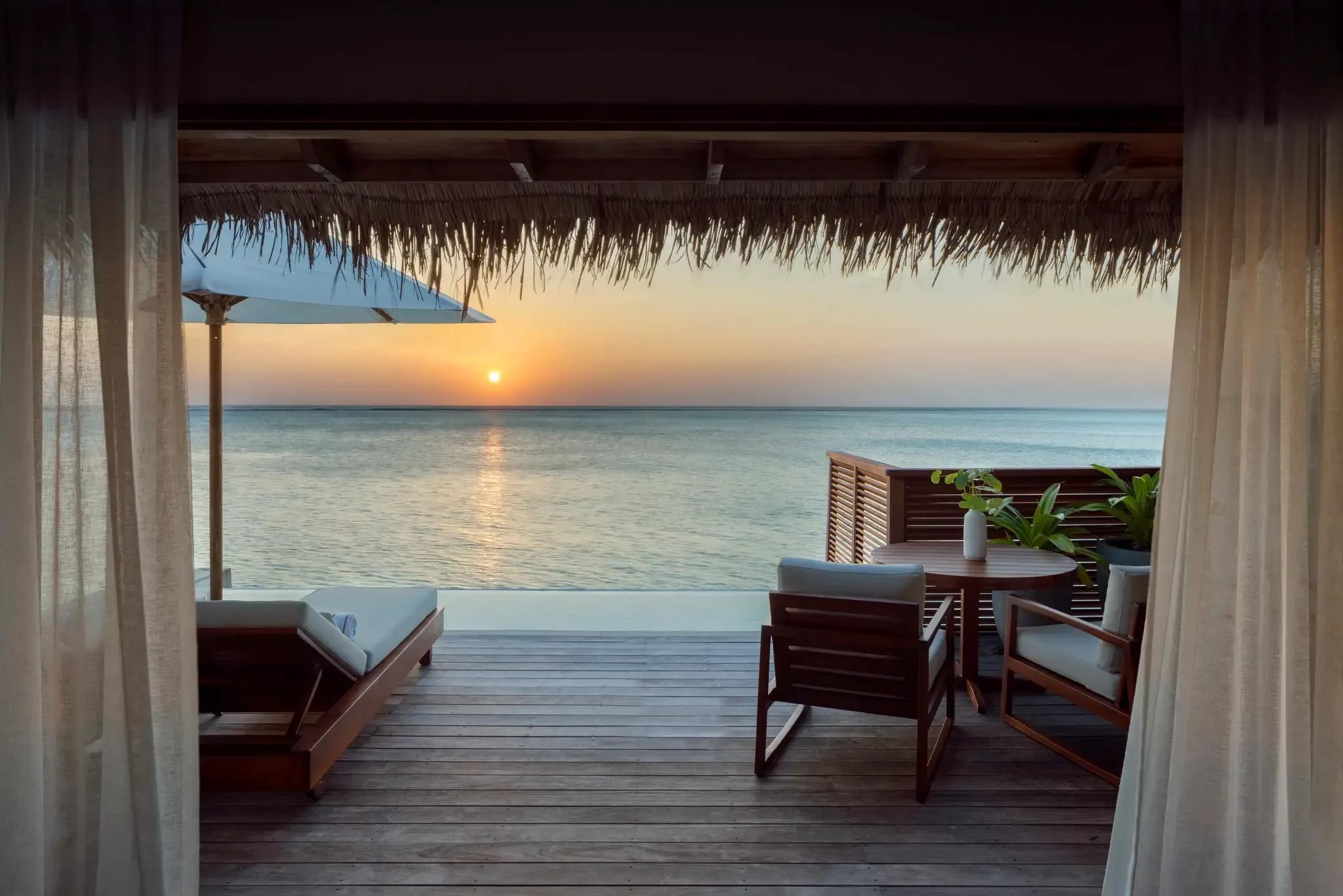 The deck and plunge pool of a Sunset Water Villa with Pool at Conrad Maldives Rangali, facing the sunset over the lagoon