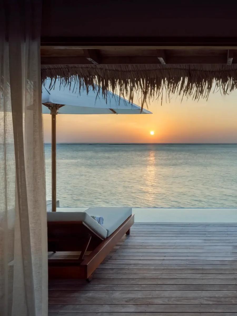 The deck and plunge pool of a Sunset Water Villa with Pool at Conrad Maldives Rangali, facing the sunset over the lagoon