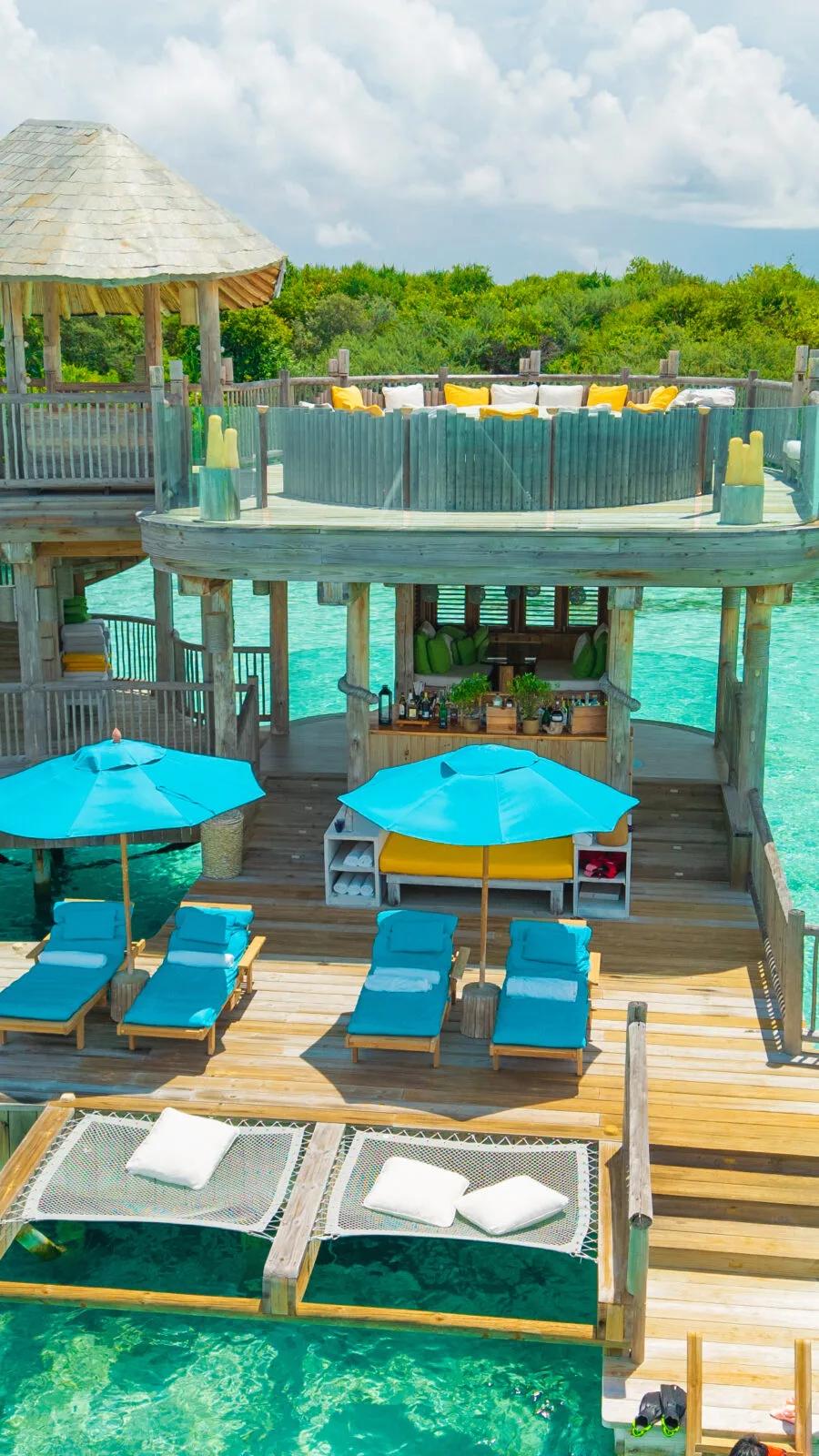 The elevated, open-air lounge deck at Director's Cut, Soneva Jani's Japanese restaurant, set above the lagoon