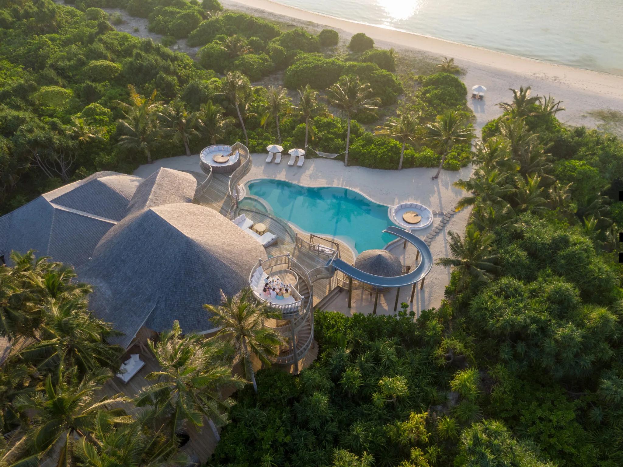 Aerial view of a three-bedroom Island Reserve villa at Soneva Jani, its roof and pool deck set among the island's own greenery