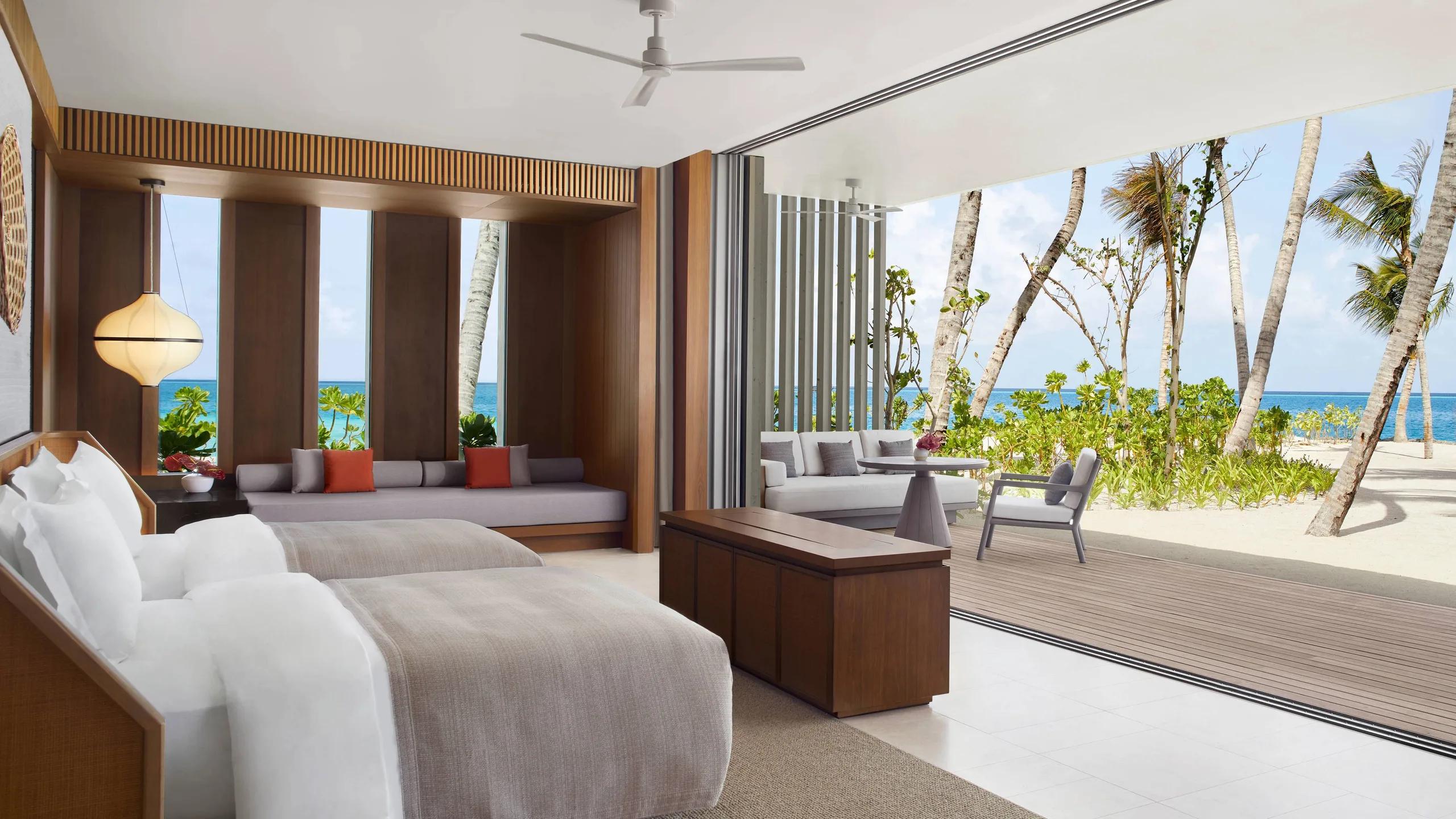 The twin-bed room of a Two Bedroom Beach Pool Villa, opening onto a beachfront lounge