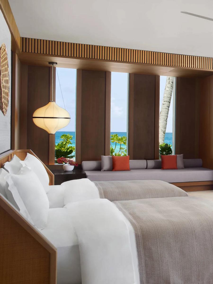 The twin-bed room of a Two Bedroom Beach Pool Villa, opening onto a beachfront lounge