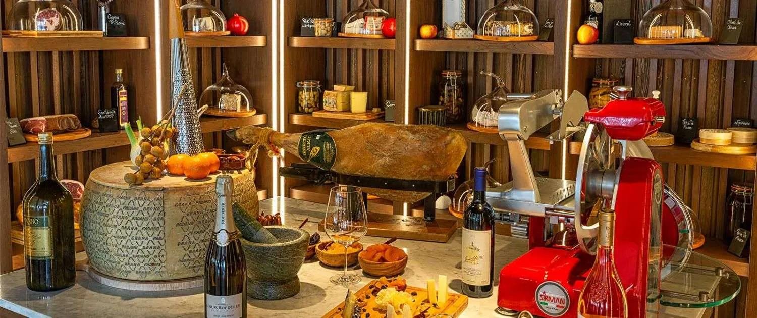 A marble tasting counter in the Wine Cellar set with cheese, cured ham and open bottles