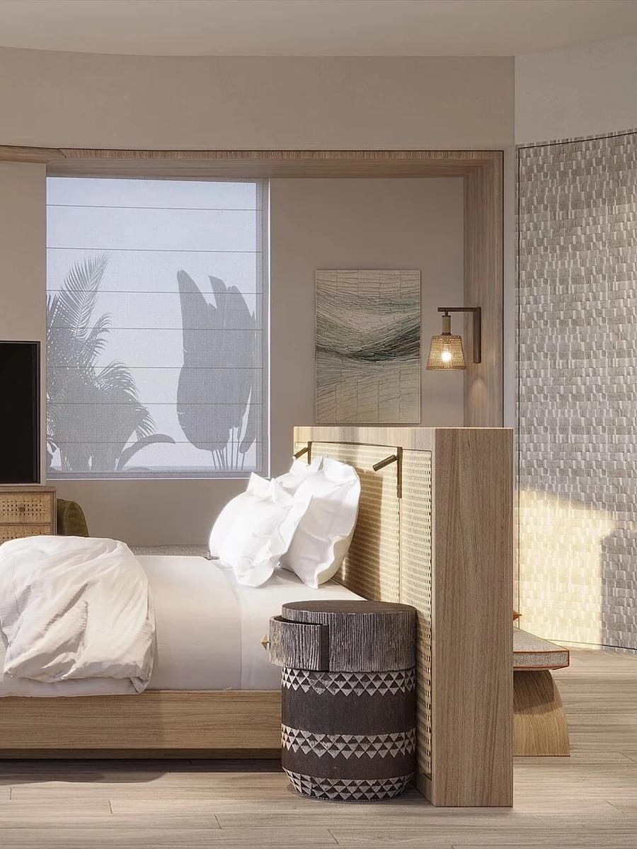 A Grand Lagoon Villa bedroom with floor-to-ceiling glass doors opening onto a private terrace and the lagoon beyond