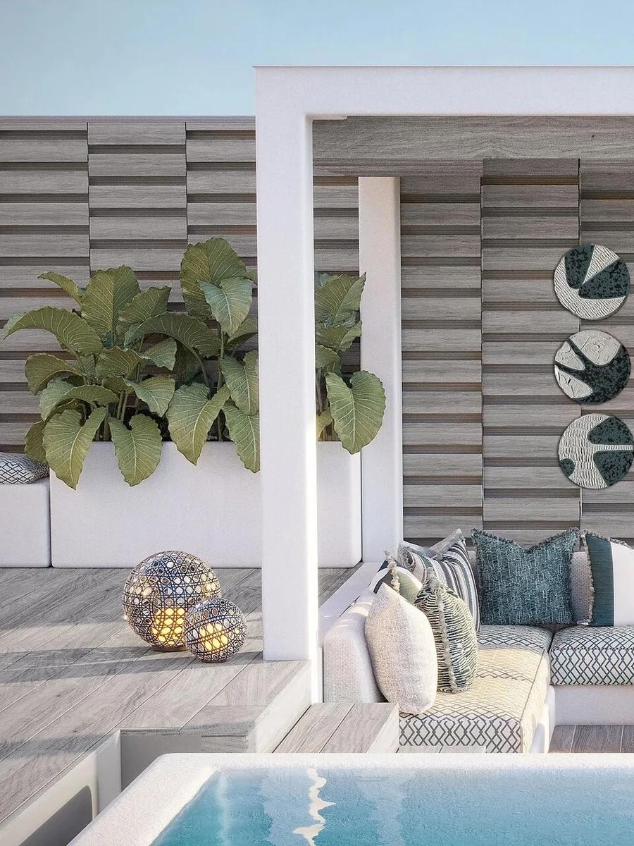 A shaded rooftop lounge on a Lagoon Villa's terrace, with a nine-piece ceramic wall installation above a built-in sofa