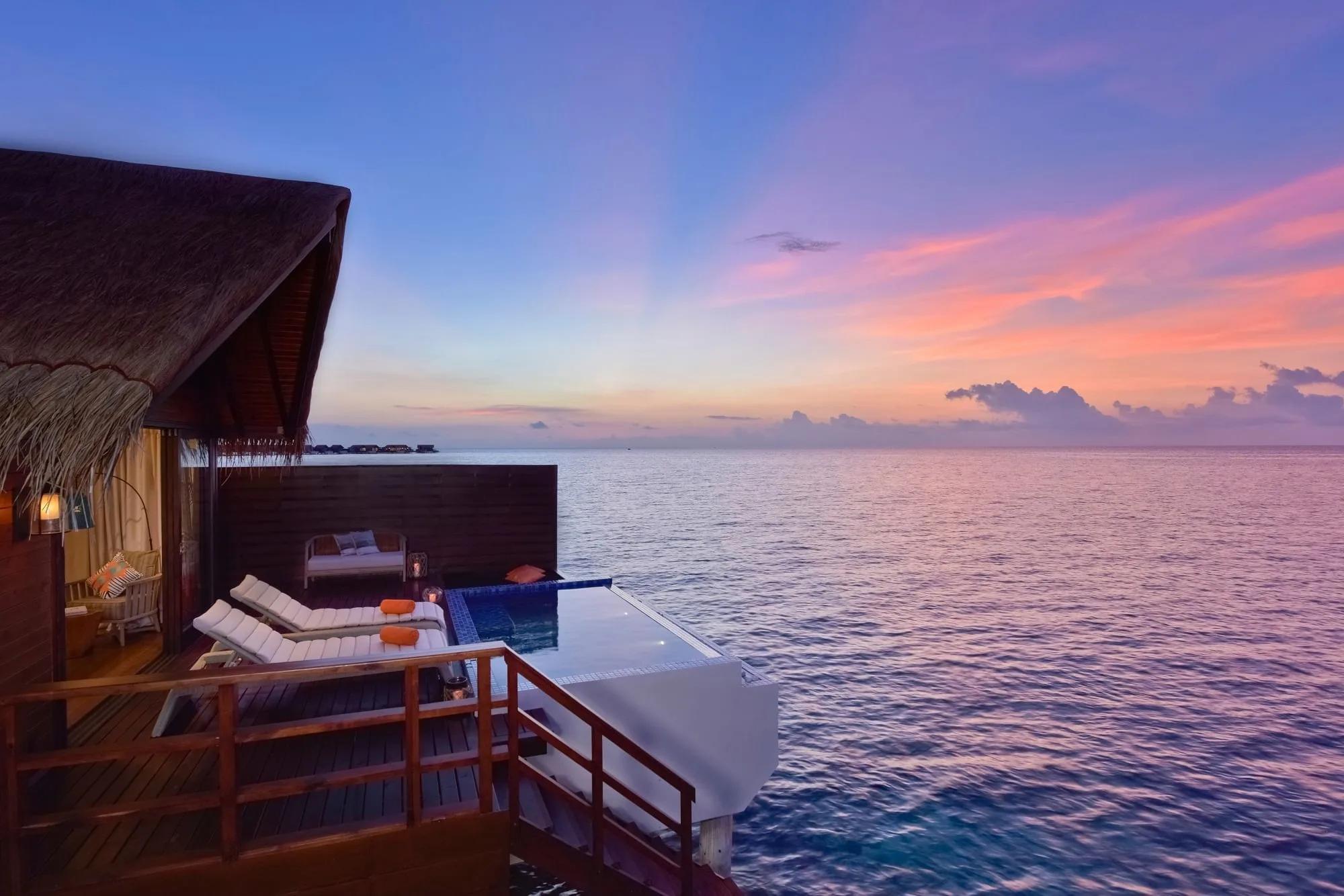 A Pool Water Villa's deck and pool at sunset