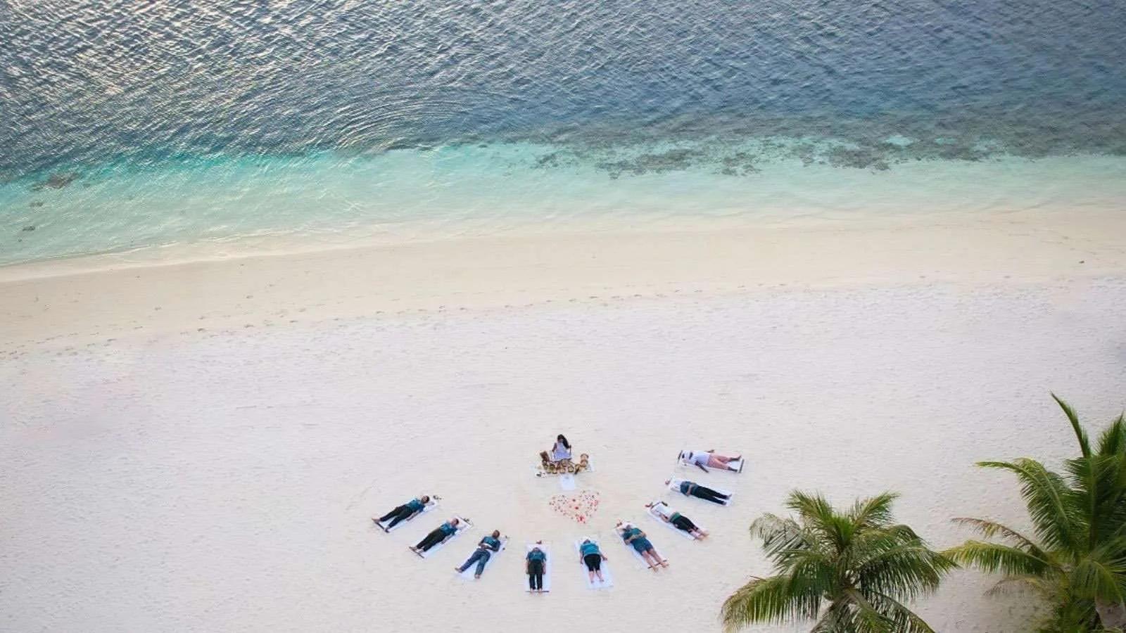 Aerial view of a beachfront group wellness session at Hideaway Beach Resort & Spa