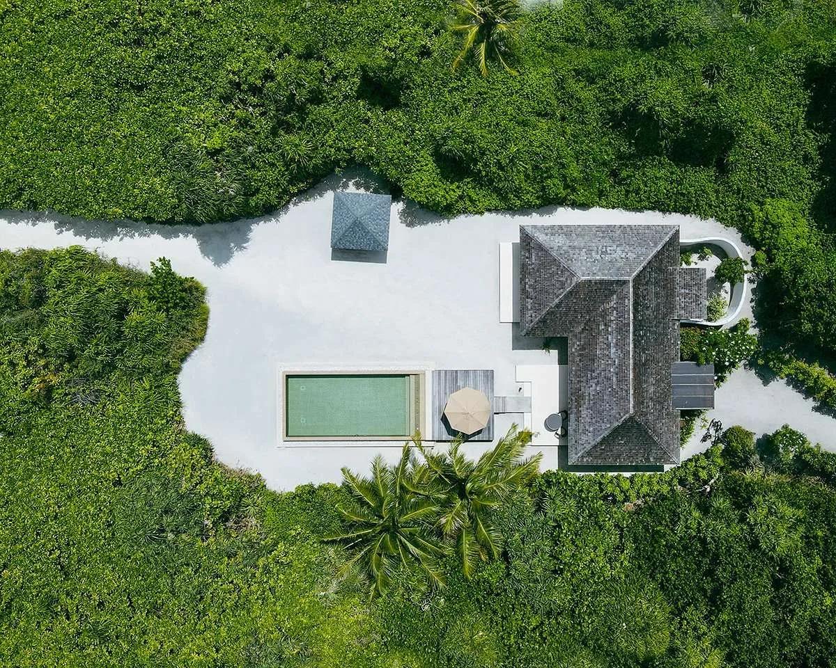 Aerial view of a Deluxe Sunset Beach Villa with Pool, its private pool and sundeck framed by greenery