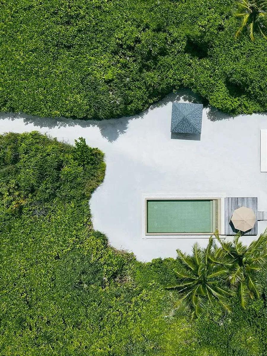 Aerial view of a Deluxe Sunset Beach Villa with Pool, its private pool and sundeck framed by greenery