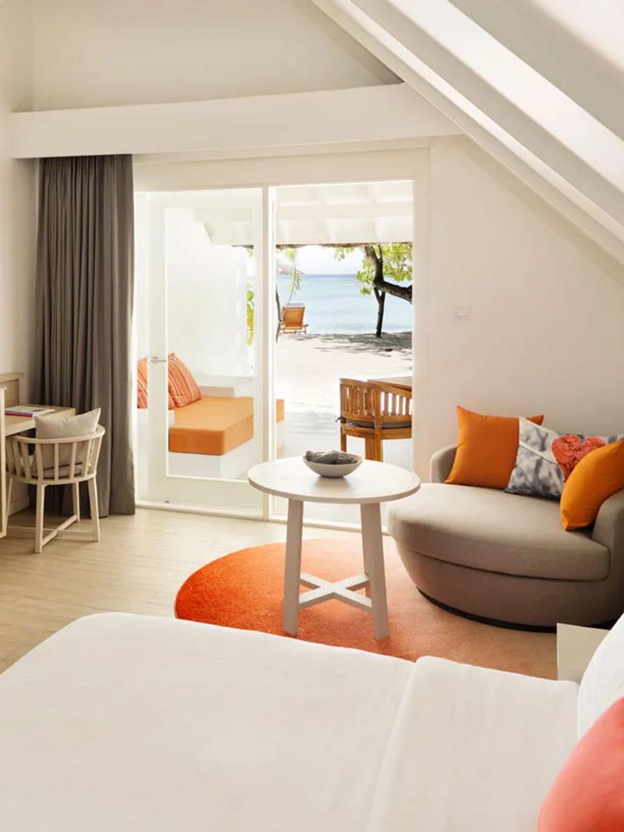 Interior of a Beach Pavilion bedroom, with sliding doors open to a beachfront terrace and the sea beyond