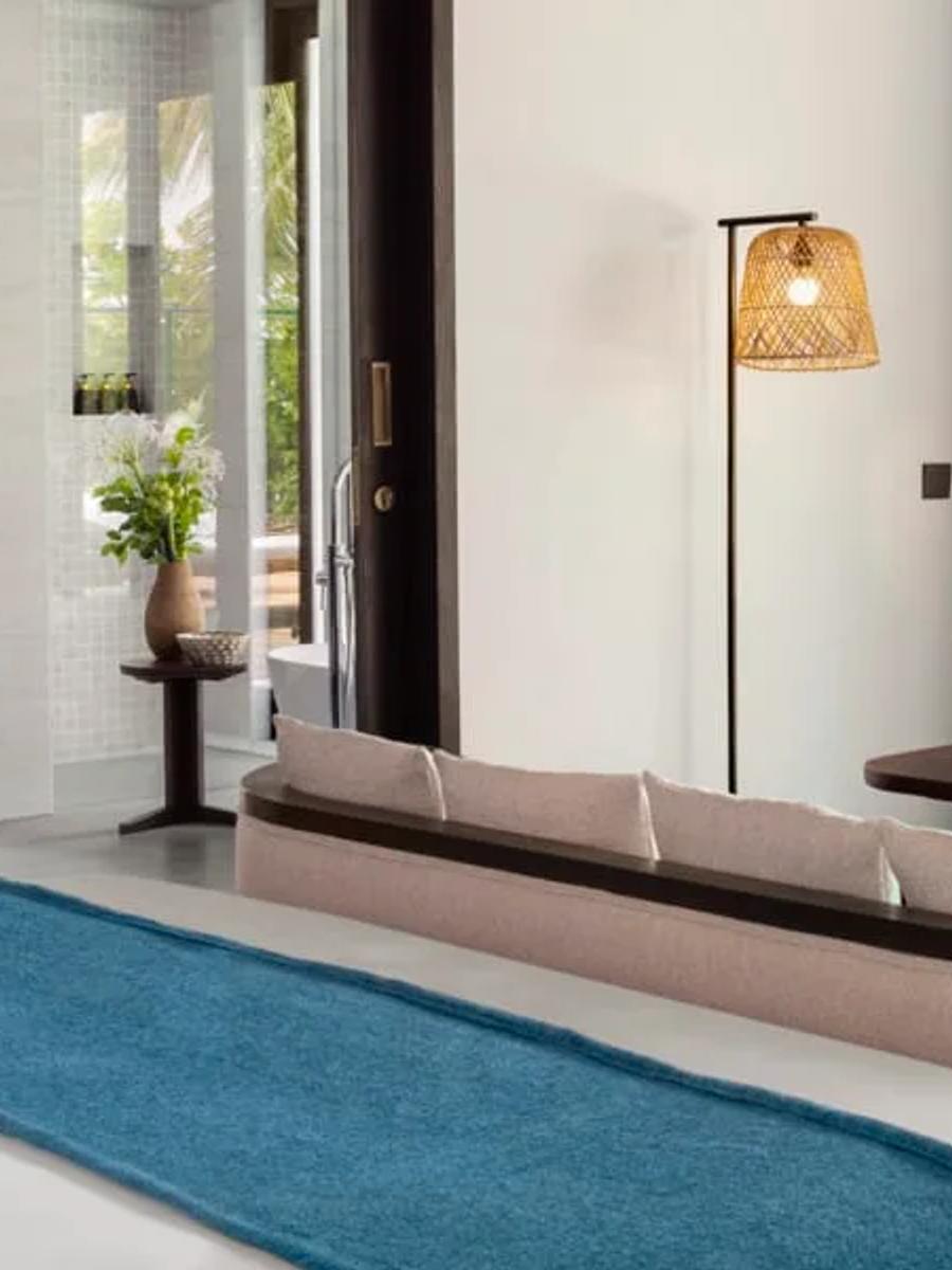 Beach Pool Villa bedroom opening onto its private pool and deck through palm trees