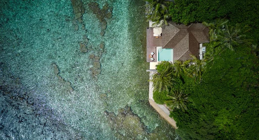 Aerial view of an Ocean Pool Villa with its private pool beside the lagoon's reef edge