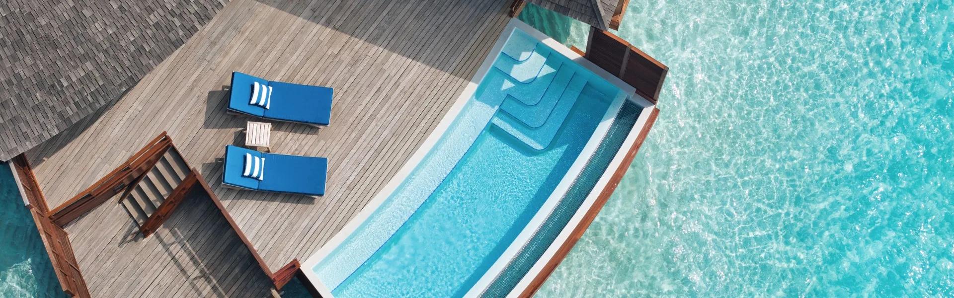 Aerial view of an over-water pool villa's outdoor deck and plunge pool above the lagoon