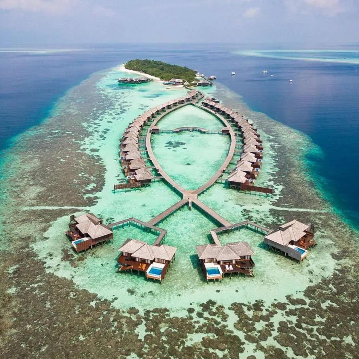Aerial view of Lily Beach Resort & Spa on Huvahendhoo, South Ari Atoll, its villa rows and lagoon jetty framed by reef