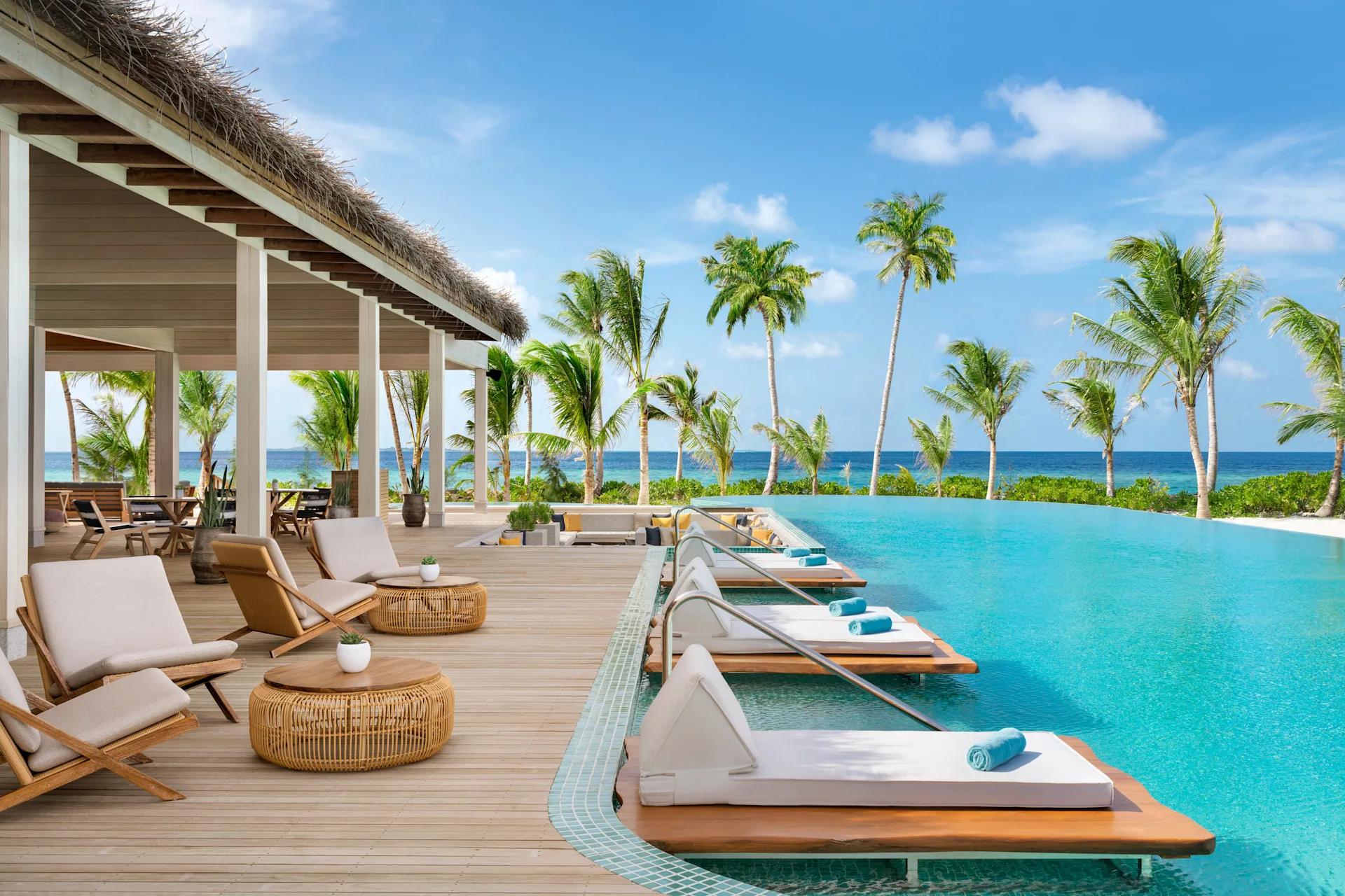 The resort's main pool, palm-lined with sun loungers along its edge